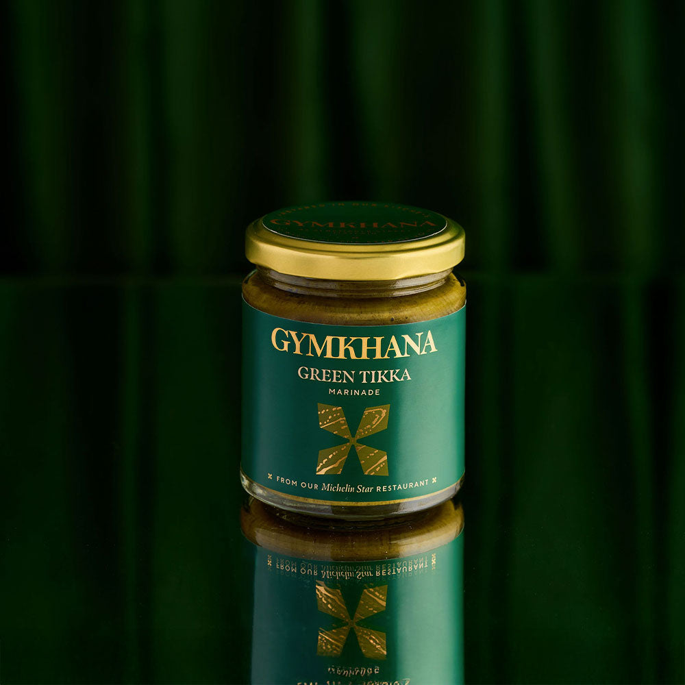 Jar of Gymkhana roasted garlic and chilli marinade on reflective surface.